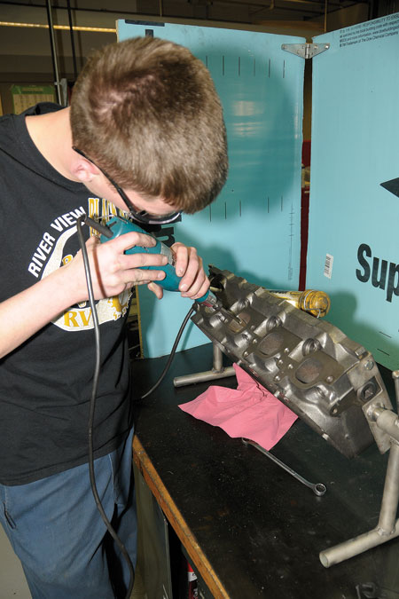 student kasey king performs exhaust port grinding to his gmc?454 engine.