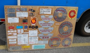There are a number of air cleaner decals on this product display board that Fusick Auto Parts brings to swap meets.
