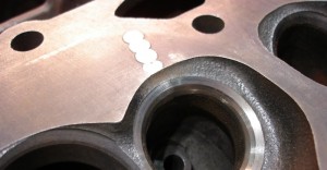 This nearly invisible crack repair extends through the valve seat. Steel pins should be used in the valve seat area because steel can withstand heat better than cast iron.